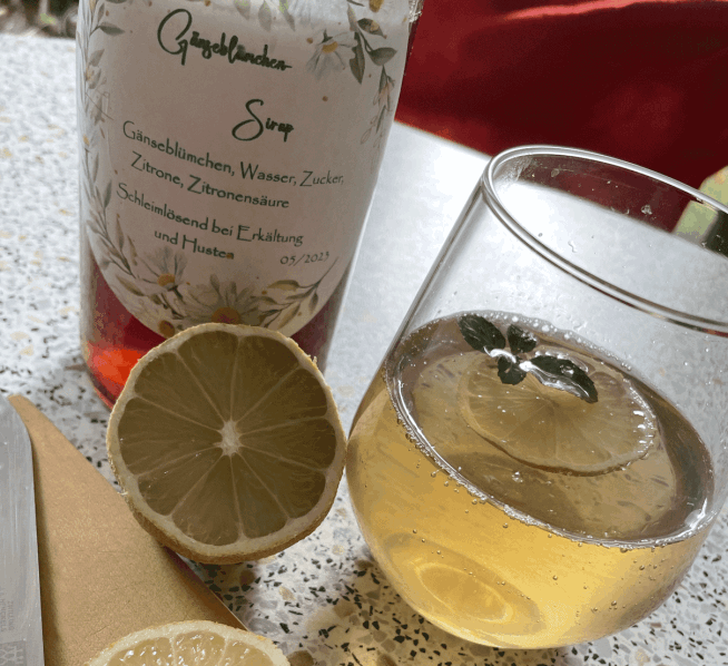 Gänseblümchen-Sirup mit Glas und Zitrone